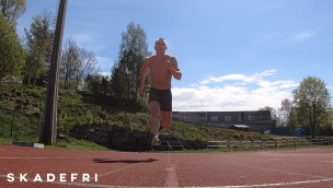 Utøver som trener på friidrettsbanen, løper fremover.