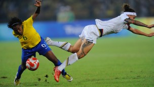 To fotballspillere i kamp om ballen der en faller forover.