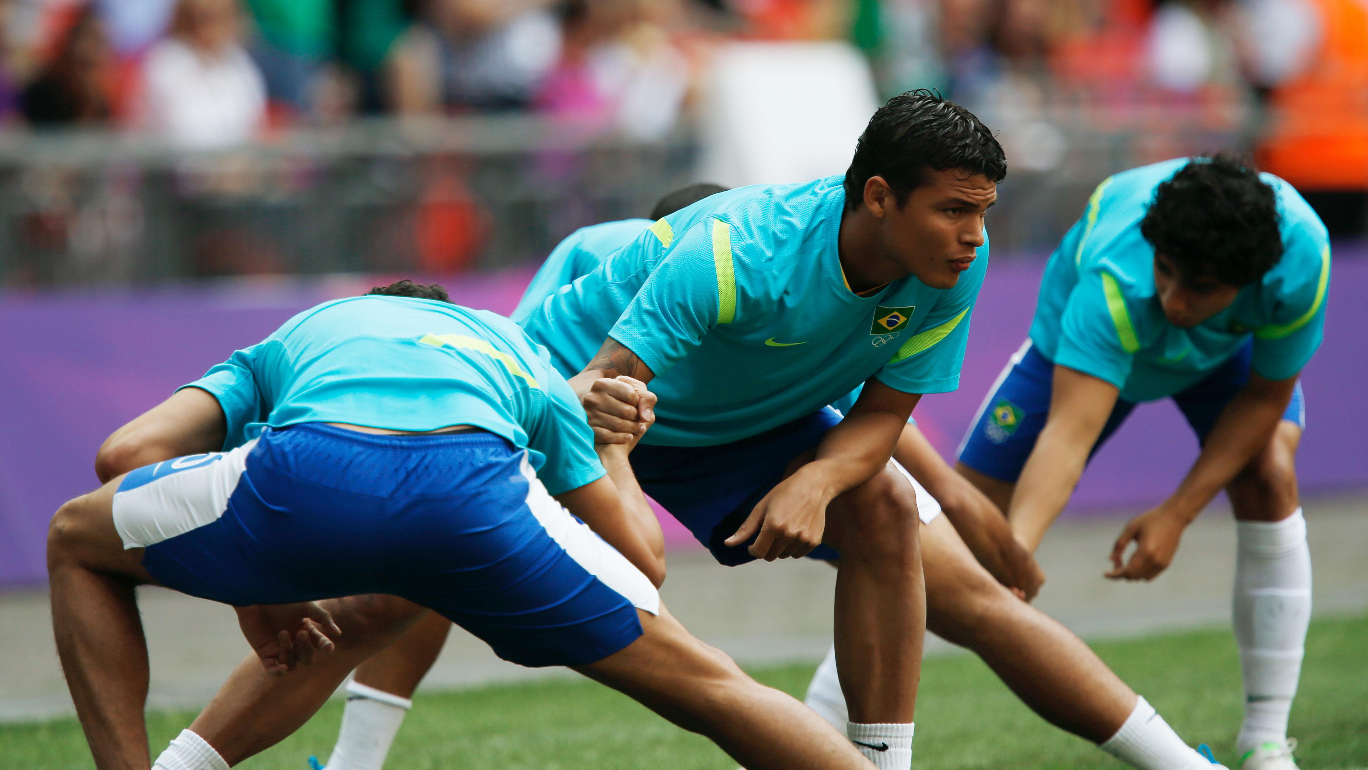 Flere utøvere på banen som tøyer hofte og lyske