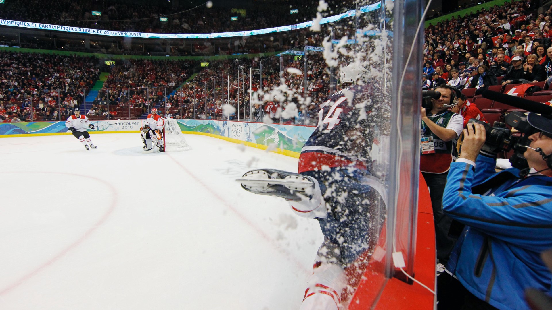 Ishockey spillere på isen som blir taklet.