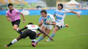 Spillere i en rugbykamp hvor en spiller prøver å takle enn annen spiller.